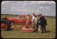 A committee examines a deck mower attached to a tractor at the Memphis Municipal Airport, 1955