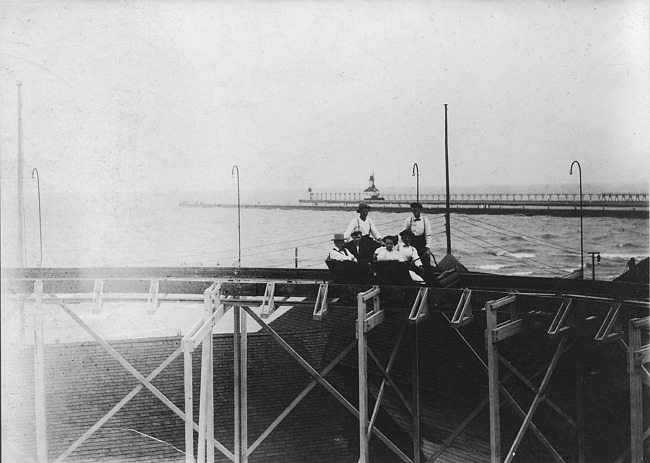 Men in car at top of Roller Coaster