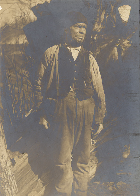 Man with tree stump in Negaunee