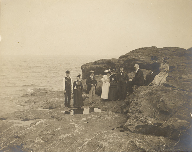 People on rock at edge of lake