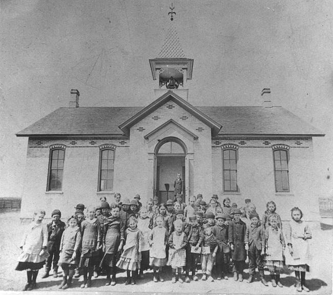 Children posing in front of school