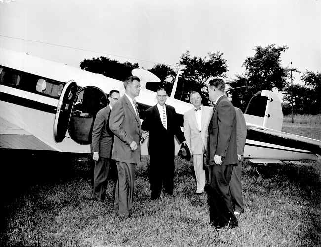 Governor G. Mennen Williams standing in front of an airplane at Mettetal Airport
