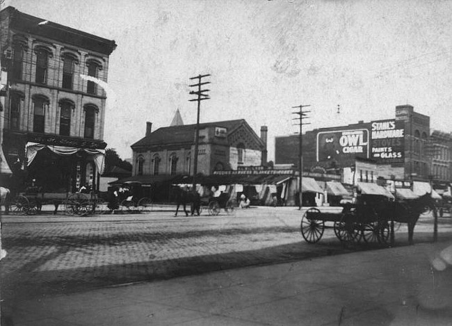 View of North Washington with horses and carts, 200 block, Lansing