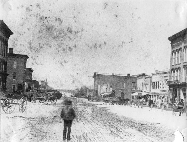 View of South Washington with horses and carts, 100 Block, Lansing