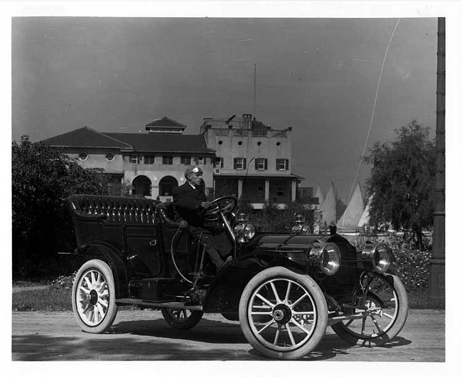 1909 Packard 30 Model UB touring car with male driver in front of the Detroit Boat Club