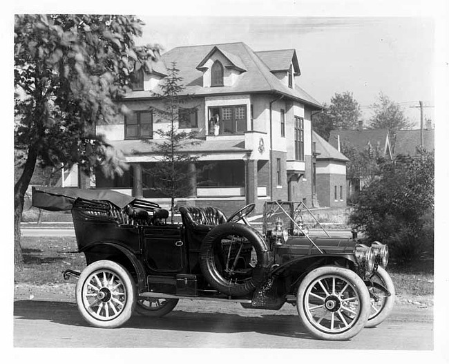 1909 Packard 30 Model UB touring car, parked on street in front of large house