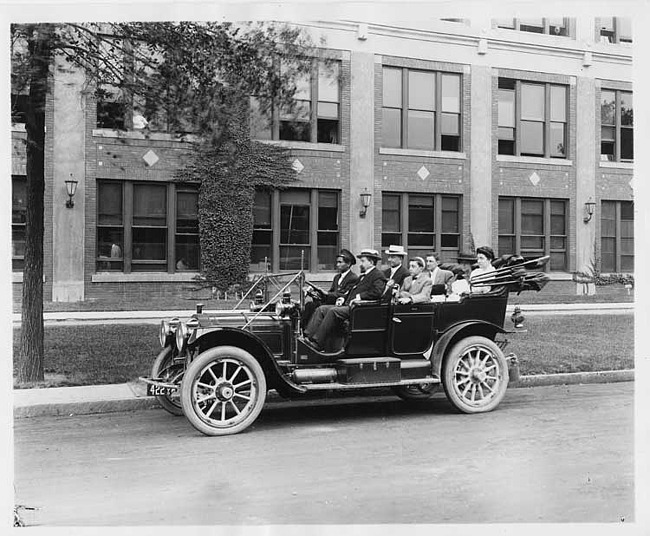 1910 Packard 30 Model UC, parked on street in front of Packard plant, with family of six and chauffeur