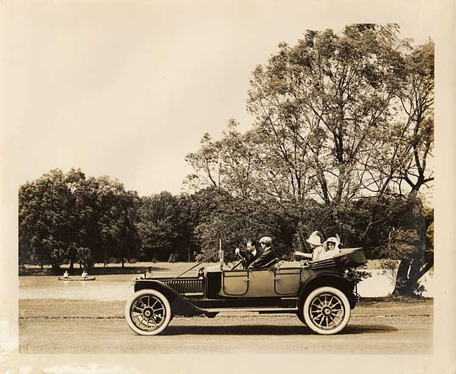 1912 Packard with top folded, two males in front, two females in back