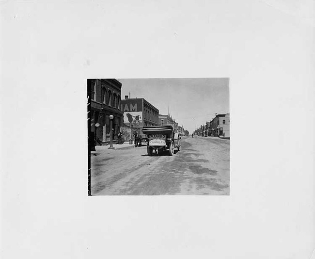 1912 Packard 6 touring car, on city street, sign on back