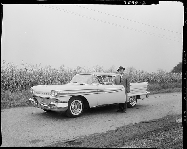 Man in suit standing by car