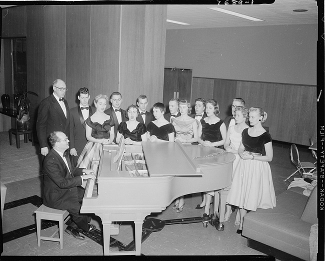 Choral group singing at piano