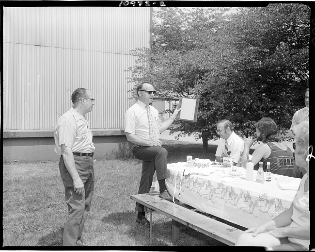 Man presenting award at company picnic