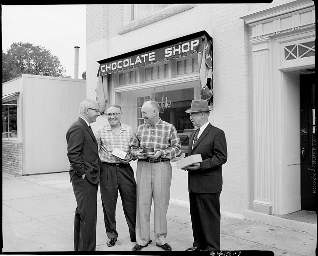 Men standing outside chocolate shop