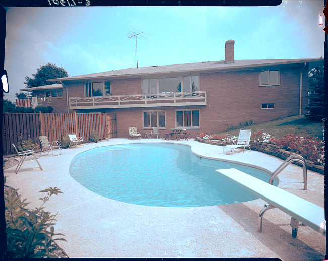 House with kidney-shaped pool in backyard