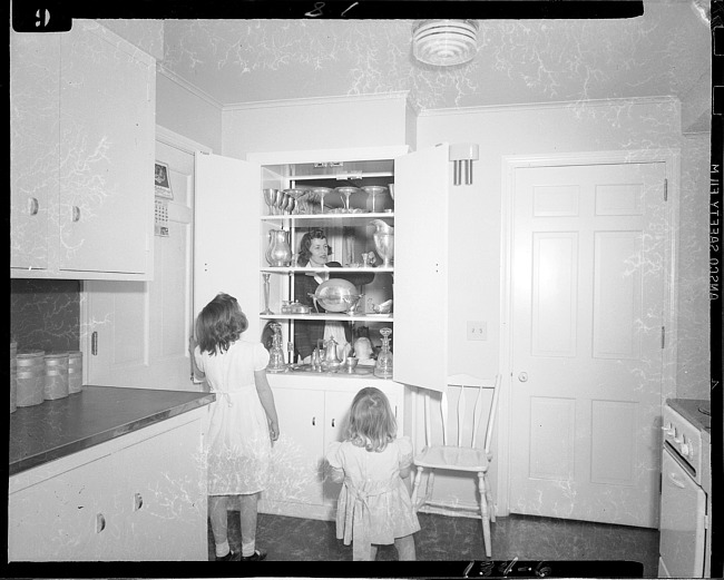 Kitchen design, girls looking at pass through cupboard