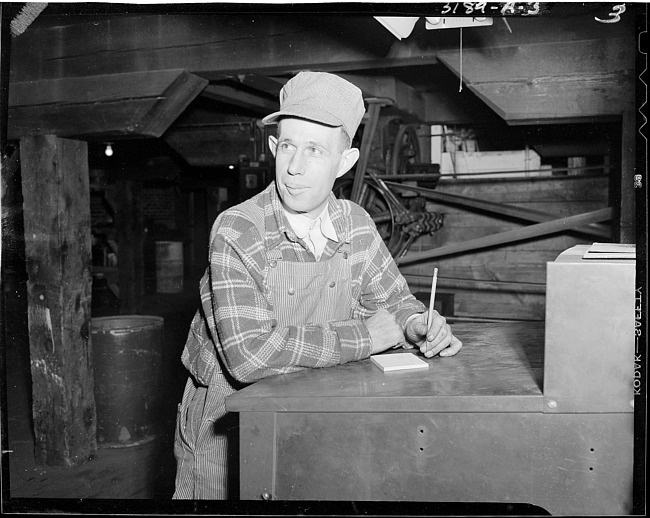 Man writing note in paper company plant