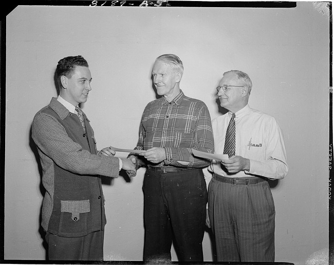 Men shaking hands and presenting check