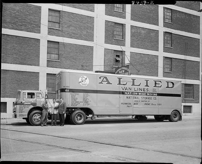 Businessmen with Allied Van Lines truck driver posing in front of truck