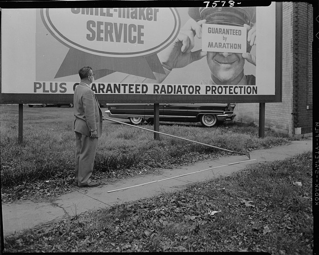 Man holding billboard scraping tool