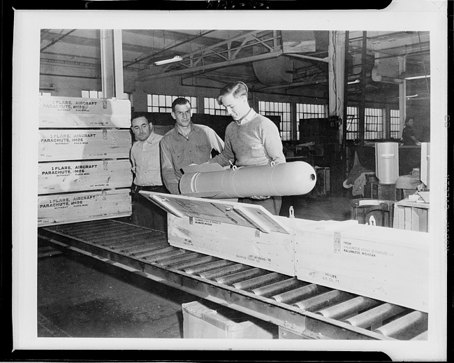 Workers inspecting aircraft parachute WWII