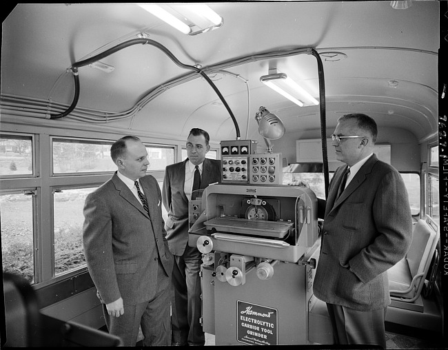 Businessmen in show bus with machinery