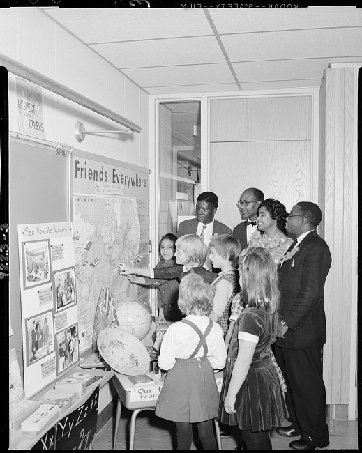 Schoolchildren with visitors looking at map