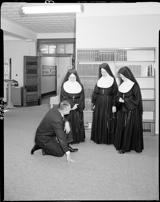 Three nuns with man in library