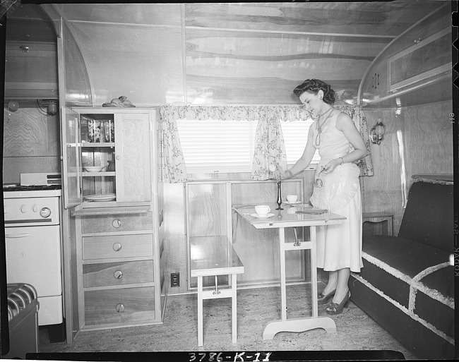 Woman setting table in Kozy Coach trailer