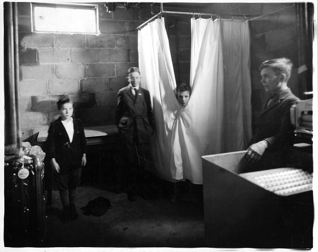 Boys by shower in basement, photograph