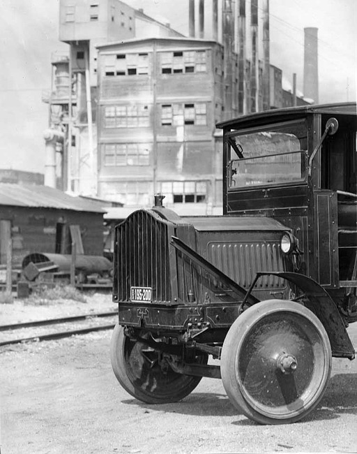 1918-1919 Packard truck, close-up view of the front quarter, factory in background