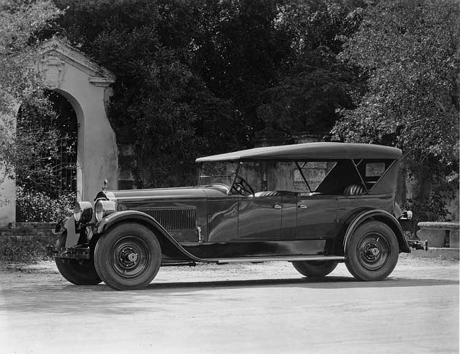 1923 Packard touring car parked by stone arch