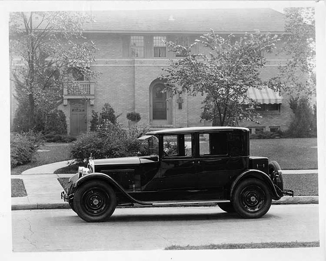 1925 Packard left side view, parked on residential street, in front of large brick home