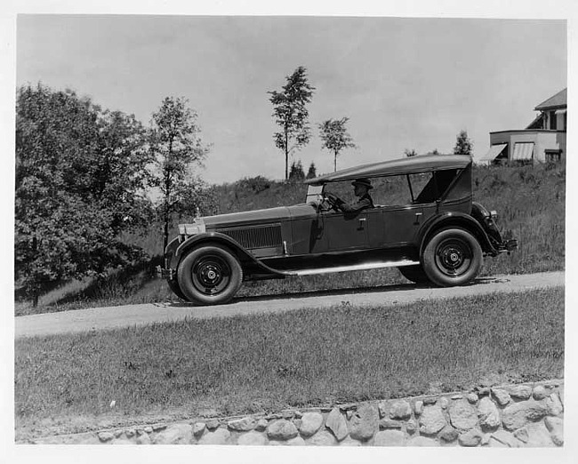 1925 Packard touring car, left side view, top raised, with male driver on country road