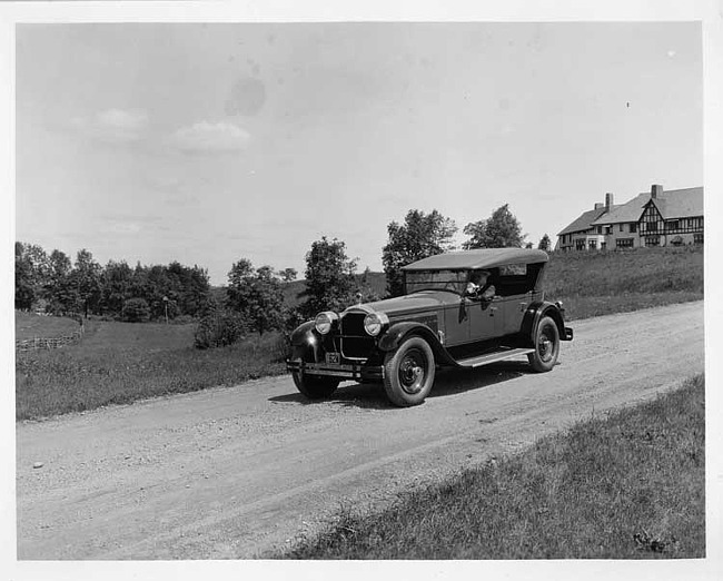 1925 Packard touring car, three-quarter left front view, top raised, with male driver on country road