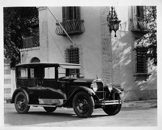 1925 Packard sedan, three-quarter right front view, parked in front of large home