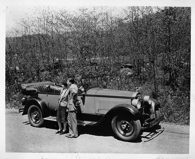 1927 Packard touring car, male and female standing at driver's side door