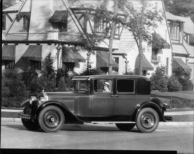 1928 Packard club sedan, parked on residential street, female driver at wheel