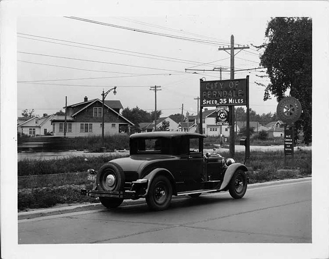 1928 Packard coupe on Woodward Ave. entering city of Ferndale, Mich.