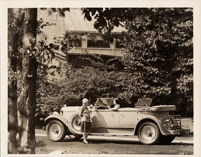 1929 Packard sport phaeton parked on street with two women