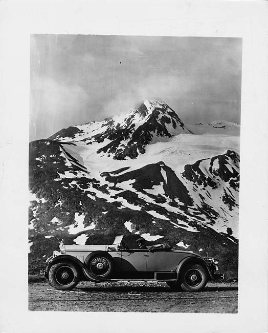 1929 Packard runabout, right side view, male driver, mountains in background