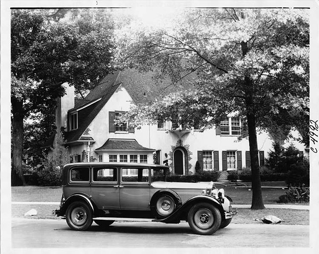 1930 Packard sedan, right side view, parked on street, in front of house