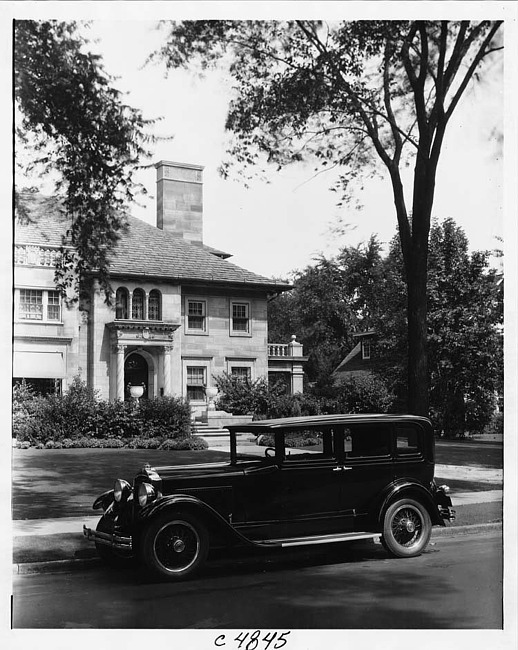 1930 Packard sedan, nine-tenths left side view, parked on street in front of house