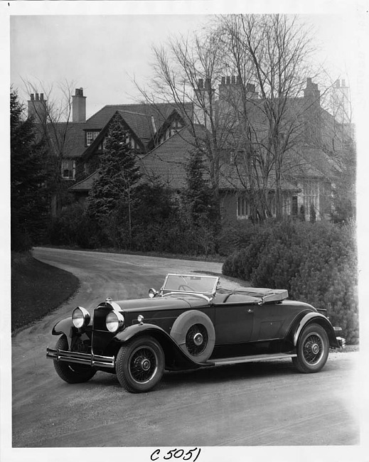 1930 Packard roadster, three-quarter right front view, top folded, parked on road, house in background