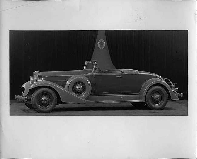 1933 Packard coupe-roadster, curtains and emblem on wall in background