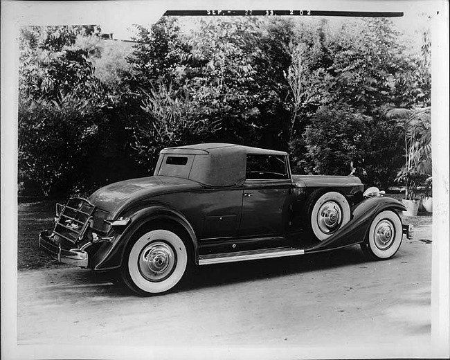 1933 Packard coupe-roadster, three-quarter rear right view, top raised, parked on drive