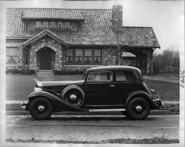 1933 Packard coupe sedan, left side view, parked on street in front of house