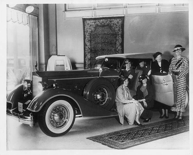1934 Packard convertible victoria in a showroom with women