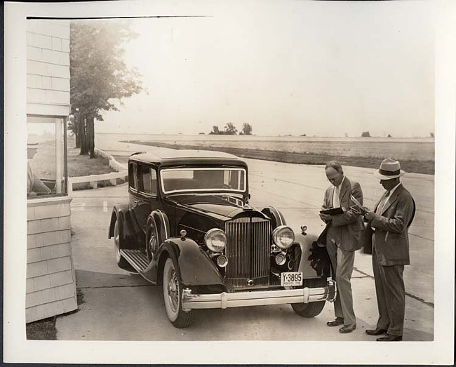 1934 Packard coupe, three-quarter front view, two men standing at front driver's side