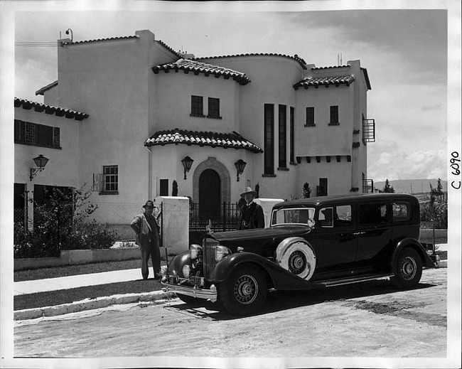 1934 Packard sedan limousine, parked in front of large southwestern style home