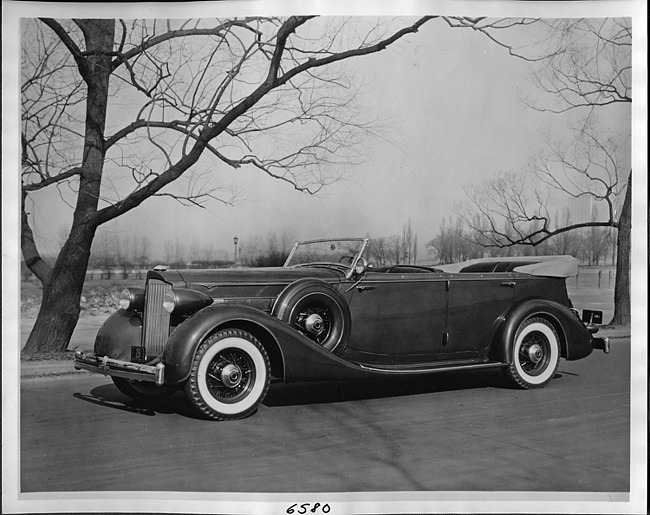 1935 Packard phaeton, seven-eights left side view, top folded, parked on street